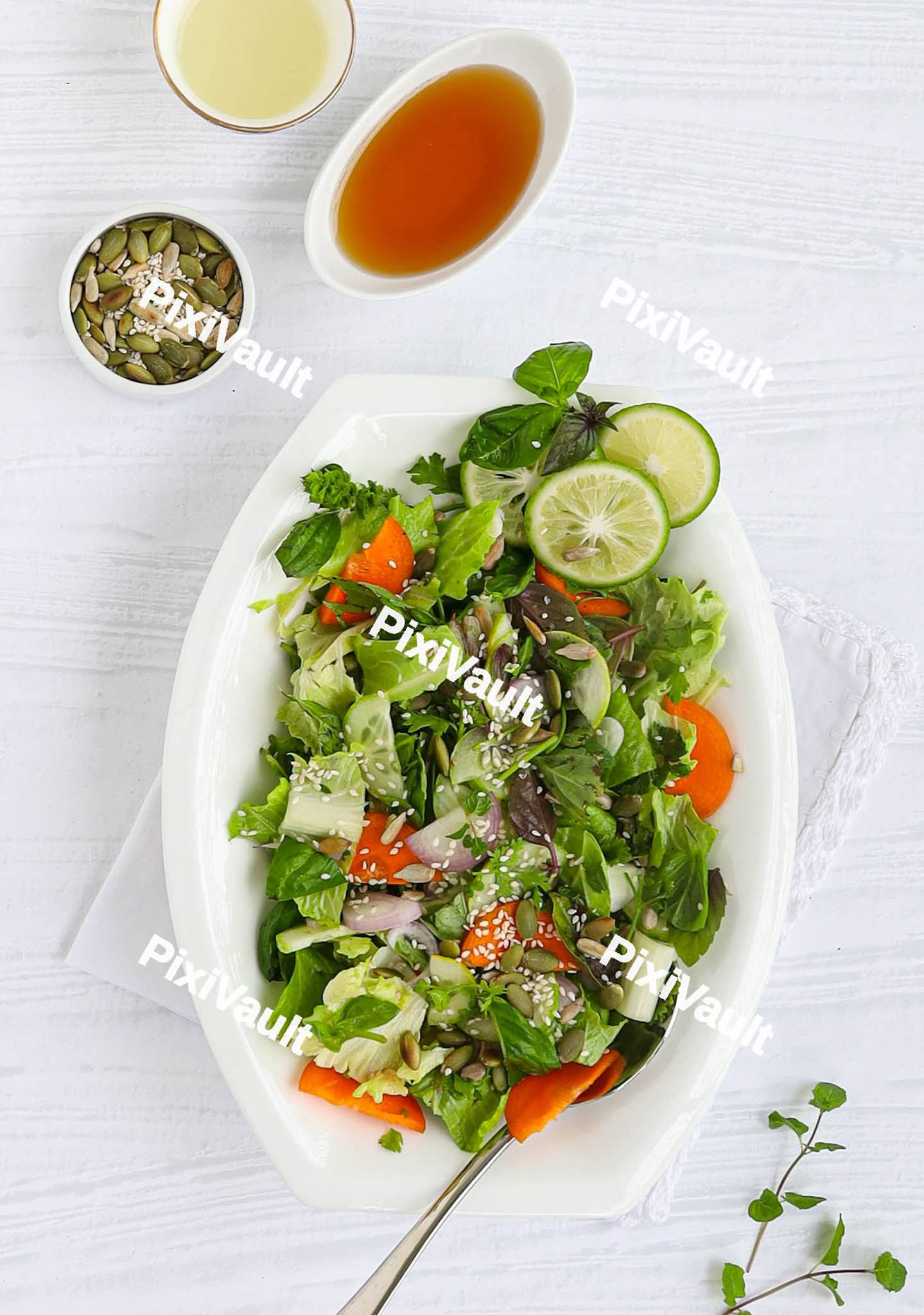 Plate with salad and bowl with sauce